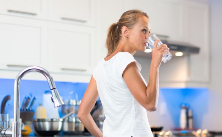 Sådan kan du undgå dehydrering: Kvinde der drikker et glas vand
