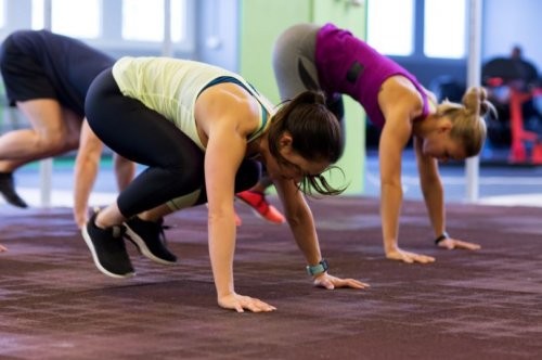 kvinder laver burpees i fitnesscenteret