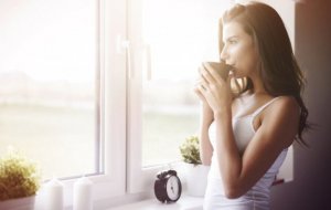 kvinder der drikker kaffe og kigger ud af vindue