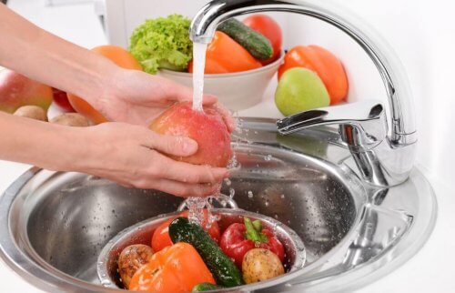 kvinde der er ved at vaske frugter og grøntsager