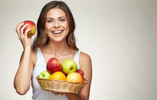 kvinde med en skål med æbler