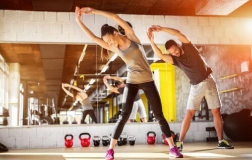 Mand og kvinde strækker ud i fitnesscenteret 
