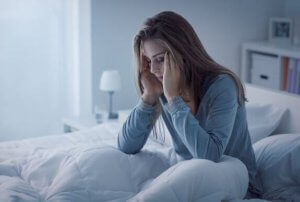 kvinde ser udmattet ud i sin seng pga. en hypokalorisk diæt