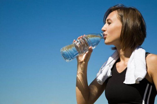 Kvinde drikker vand efter træning
