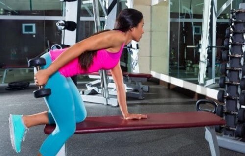 Kvinde træner med håndvægte i fitnesscenteret 