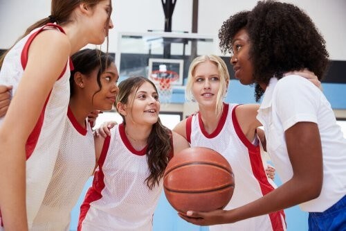 Piger spiller basketball sammen