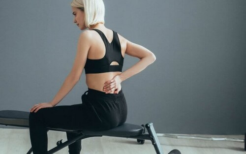 Kvinde oplever rygsmerter under træning