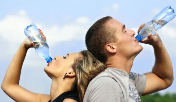 mand og kvinde der drikker vand for at sikre hydrering