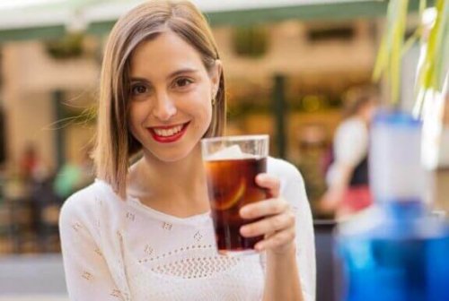 ung kvinde med et glas sodavand