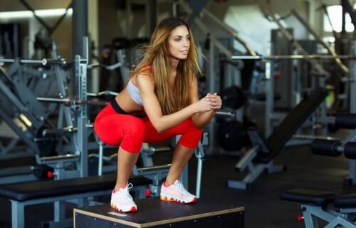 Kvinde laver squats i fitnesscenteret 