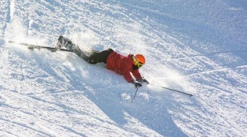 Person styrter under heli-skiing 