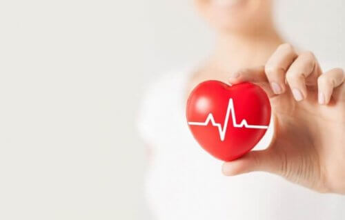 hjertefigur med hjertefrekvens i hånd