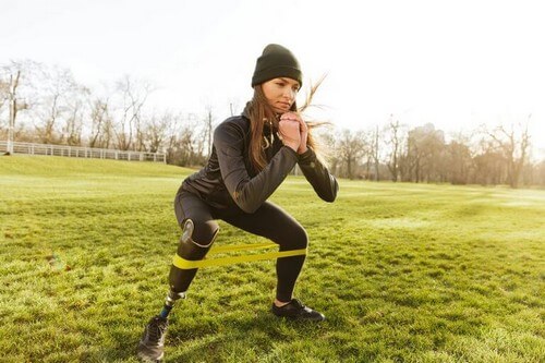 Kvinde laver squats med træningselastik 