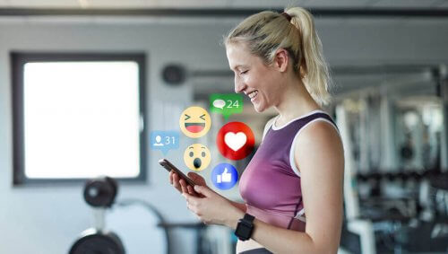 kvinde der bruger sin mobil i fitness