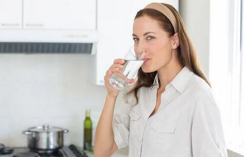 Kvinde drikker vand for at holde sig hydreret 