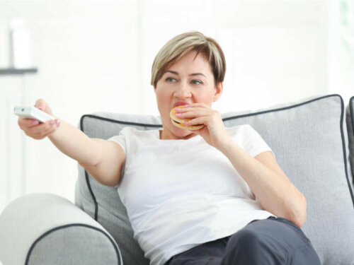 kvinde der spiser bruger og ser fjernsyn