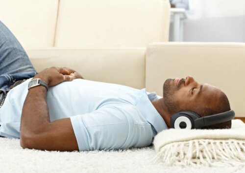mand der ligger og hører musik