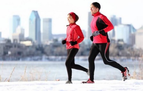 Mand og kvinde løber i vintervejret 