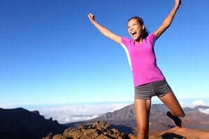glad kvinde på bjergtop