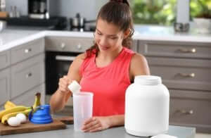 Nahrungsergänzungsmittel - Frau bei der Zubereitung in der Küche