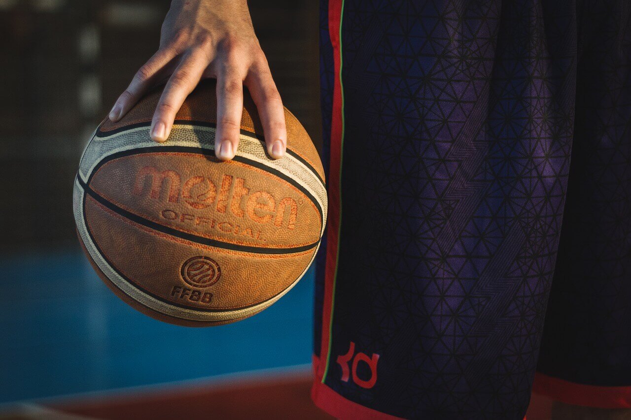 Un ballon de basket dans une main.