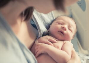 Un bébé dans les bras de sa mère.