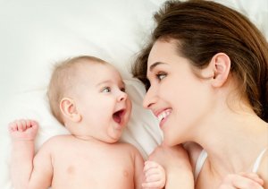 Un bébé et sa maman qui rient.