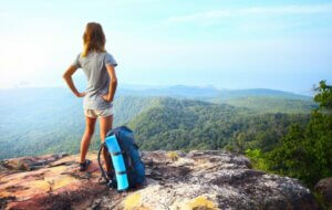 Une femme à la montagne regardant le paysage à l'horizon.