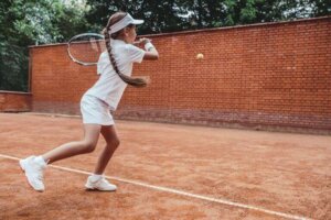 fille jouant contre un mur au tennis