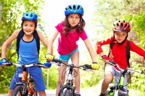 Trois enfants qui font du vélo. 