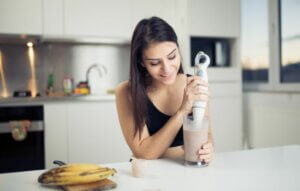 Une jeune femme qui prépare une boisson à base de protéines ou d'acides aminés. 