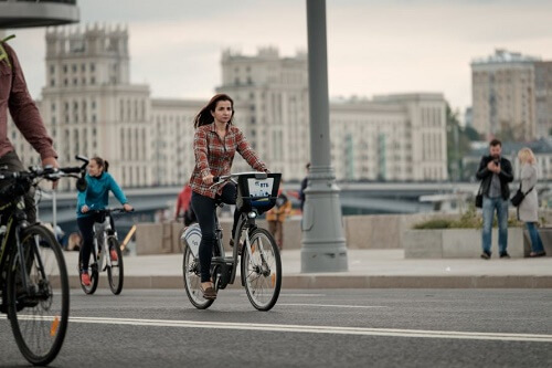 Donna in bici pedala in città