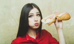 miti sulla dieta: donna che mangia panino con il prosciutto 