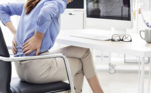 donna con mal di schiena in ufficio 