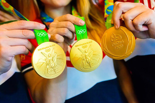 Atlete mostrano le medaglie. Carta olimpica.