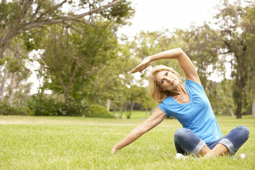Donna non giovane che fa yoga nel parco
