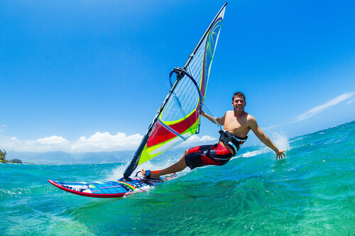 Windsurf: uomo fa windsurf su un'onda