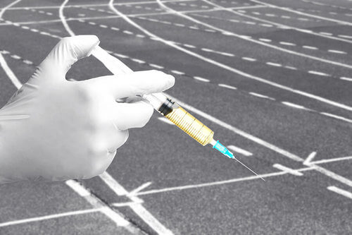 Codice antidoping: persona con siringa in mano su pista di atletica