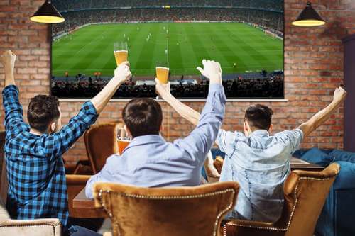 Tre uomini che guardano una partita di calcio.