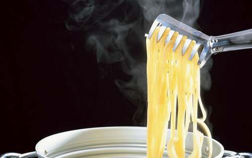 Spaghetti vengono tirati fuori dalla pentola.