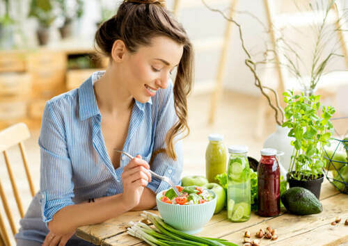 Donna felice che mangia un'insalata per migliorare il benessere.