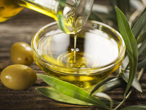 Ciotola con olio d'oliva e olive.
