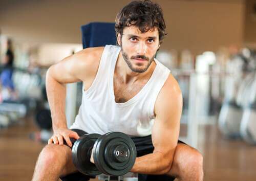 Uomo che fa esercizio fisico in palestra per combattere il metabolismo lento.