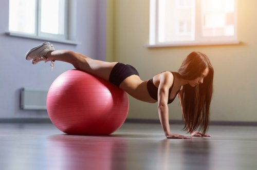 Kvinne bruker en ball med sine pilates øvelser.