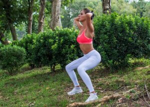 Kvinne trener i en grønn park.