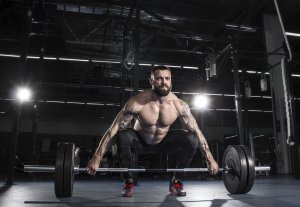 Mann trener med vekter for å øke muskelmassen.