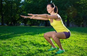 Kvinne utfører air squats i en park.