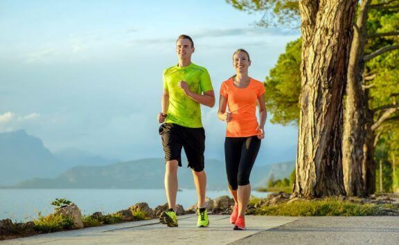 Par i treningsklær driver med power walking