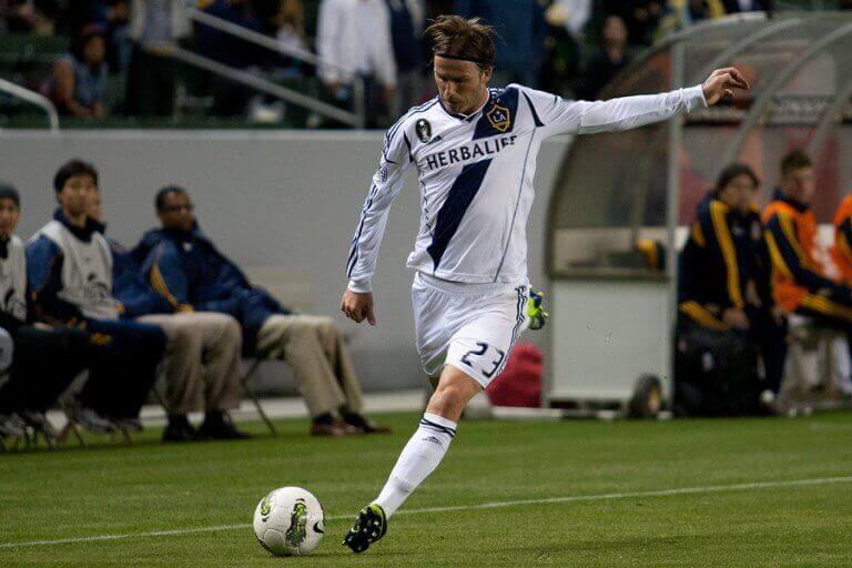 David Beckham bøyer ballen slik han er kjent for. 
