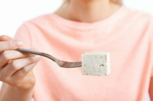 Kvinne som holder en gaffel med tofu
